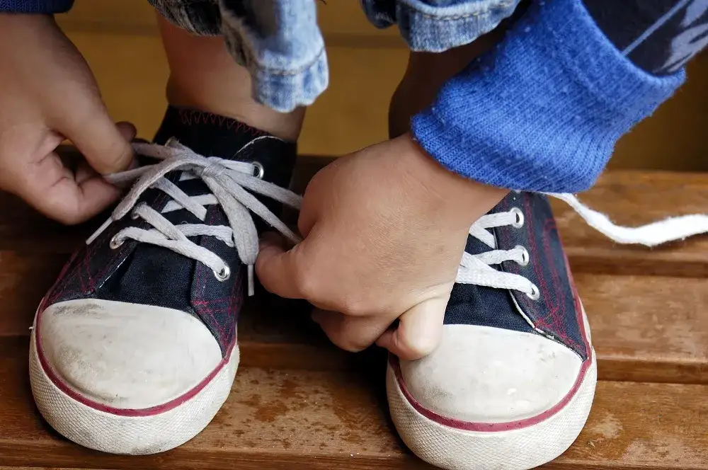 dziecko wiąże buty uszy kr&oacute;lika